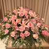 The pretty pink casket spray features a variety of pink flowers and