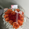 This heart-shaped arrangement combines the warmth of orange roses, the intensity of