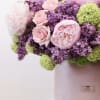 The arrangement includes the following flowers; peonies, lilacs, spray roses and hydrangea.