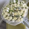 A breathtaking arrangement of pure white roses, delicate tulips, and soft accent