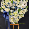This is a heart-shaped floral wreath designed for a funeral or memorial