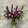 This arrangement is bursting with orchids. What makes this arrangement a little