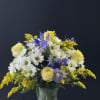 A mint green vase full of daisies and blue iris.