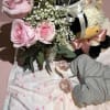 A delicate arrangement featuring soft pink tones, fresh foliage, and a cuddly