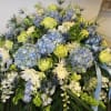 Blue hydrangea, green roses, thistle in a beautiful spread for a casket