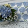 Blue hydrangea, white roses, white daisys in a white ceramic
