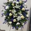 A beautiful mix of white lilies, white roses, blue delphinium, spider mums