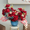  This bold and electrifying composition of velvety red roses, delicate ivory
