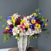 This arrangement includes a mix of premium blush roses, tulips, irises, ranunculus