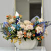A breathtaking fusion of soft blush roses, vibrant blue tulips, and golden