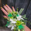 A beautiful corsage with green accents and tones made with your choice