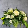 All white arrangement of roses and other white flowers in a ceramic