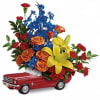 This colorful arrangement includes orange spray roses, yellow asiatic lilies, red carnations