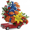 This colorful arrangement includes orange spray roses, yellow asiatic lilies, red carnations