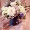 Showy arrangement of hydrangea, roses, carnations and stock in a large purple