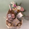 A celebration box with bubbly, chocolate, fresh flowers and a Liberty x