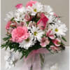 White daisies, roses, carnations and alstromeria fill the ginger jar