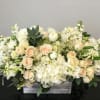 All white hydrangeas, roses, stock, and seasonals carefully arranged in a birchwood
