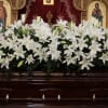 This grand casket arrangement showcases lilies with seasonal greenery. 