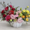 This arrangement includes a mix of ranunculus, lisianthus, and spray roses in