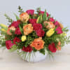 This joyful arrangement is made with bright pink spray roses, orange ranunculus