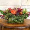 Centerpiece includes tropical flowers such as ginger, anthurium, orchids, parakeets, bromeliads, and