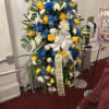 A spray like display of flowers arranged on a 5 inch stand