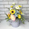 A lavender watering can arranged with artificial blue hydrangea, viking pomps, yellow