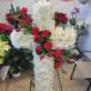 a 22&#039; cross with white spider and red roses in stand

Flowers and