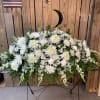 The purity of this all-white casket spray creates an aura of serenity
