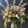 A stunning arrangement in an ashen ripple footed vase filled to the