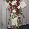 A grand, cross-shaped easel spray, created with white mums, red and white