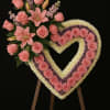 A stunning heart-shaped floral tribute designed with vibrant pink roses, lilies, and