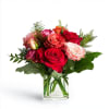 Fiery red roses, delicate pink blooms, and soft orange petals come together