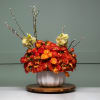 Orange roses, Spray roses, Orchids, plants in a white ceramic vase. 