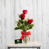 Three beautiful red roses vased with textural greens and petitie filler blooms