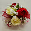 A classic red and white mini rose corsage compliments any outfit. A