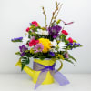 A springy collection of flowers in a bright watering can container (Assorted