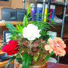 Decorated dish garden with mixed green plants and decorated with fresh flowers.