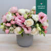 This stunning arrangement features white ranunculus, soft pink lisianthus, and an assortment