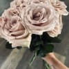 12 fresh cut roses of your color choice delicately arranged and tied