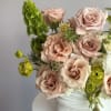 This soft and elegant arrangement features blush pink roses, creamy white blooms