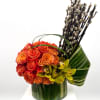 This vibrant floral arrangement features a stunning bouquet of fiery orange roses