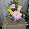 A beautiful mixture of spring flowers arranged in a decorative Easter container!