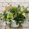 An earthy, textured bouquet of luxurious foliage, interesting green florals and preserved