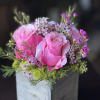 Blushing pink Roses accented by dainty pink and white Waxflower blooms and