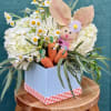 A charming nod to springtime delight, this whimsical arrangement features fluffy white