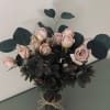A gorgeous arrangement of fresh cut spray roses and fresh foliage, prepared