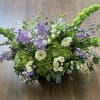 Bells of Ireland, hydrangea, spray roses, and gerberas, in a palette of