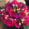 Hot pink roses, accented with sweet William and hypericum berries, in a
